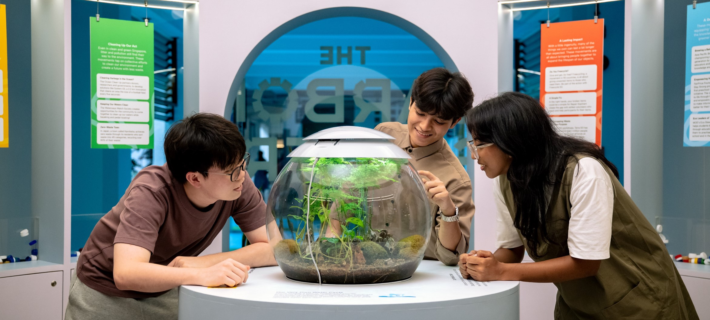 Visitors exploring an interactive eco-display at The Carbon Gallery, learning about sustainability and carbon literacy through hands-on exhibits in Singapore.